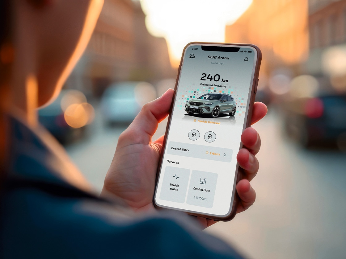 Vyras su išmaniuoju telefonu naudoja „My SEAT“ programėlę