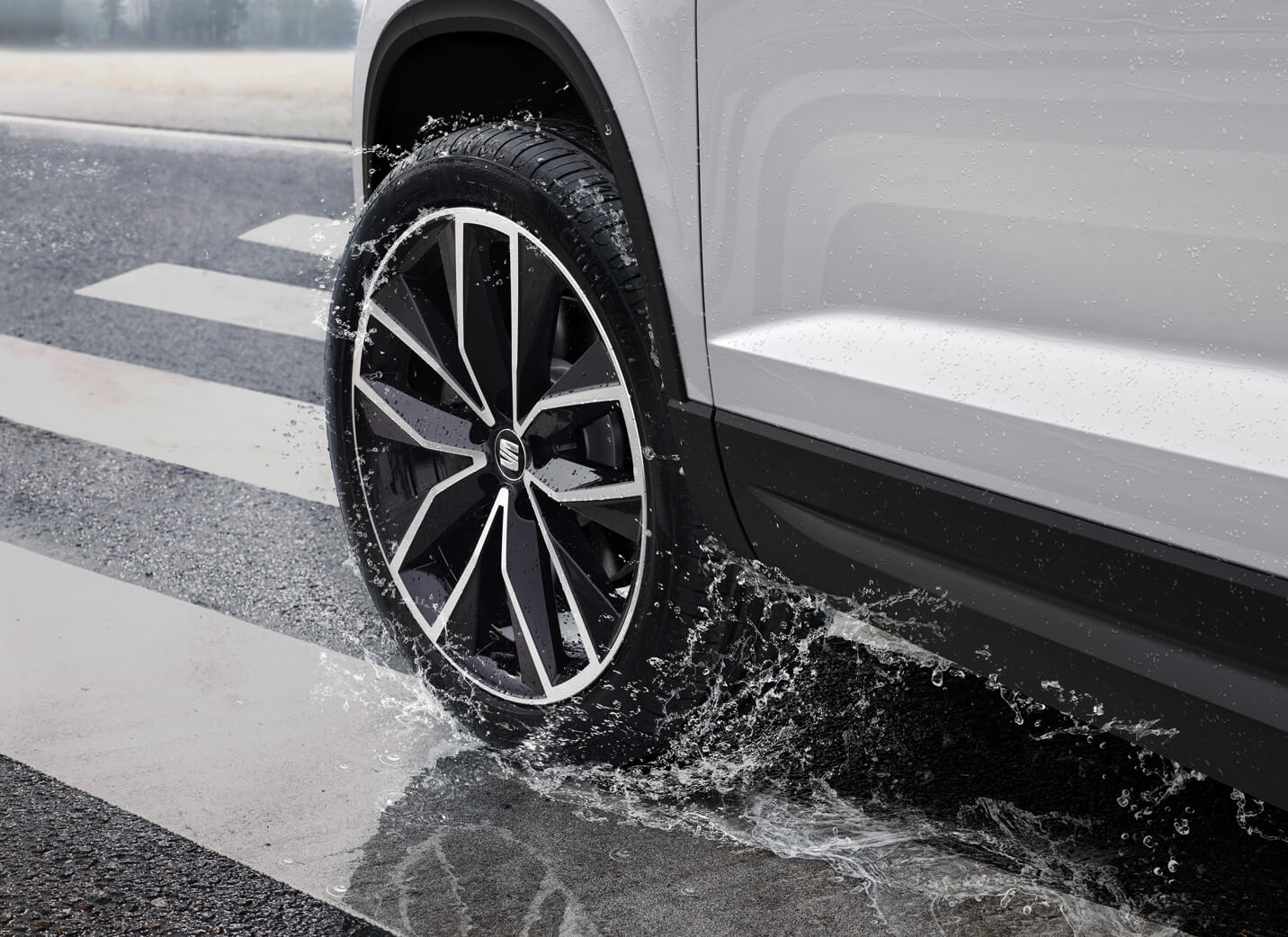 >SEAT new car services and maintenance – corner angle view looking down of a SEAT wheel driving in a puddle